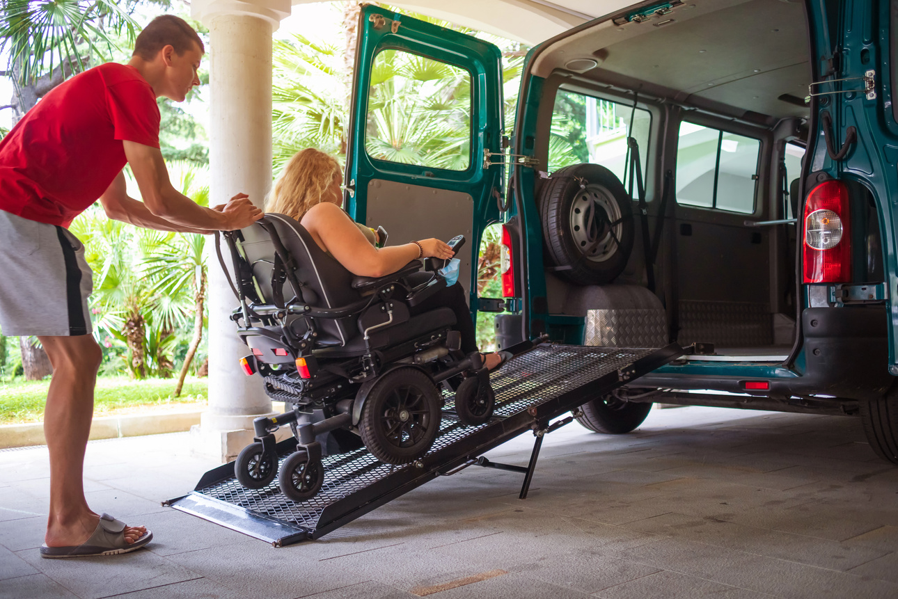 Disabled person on wheelchair using van ramp